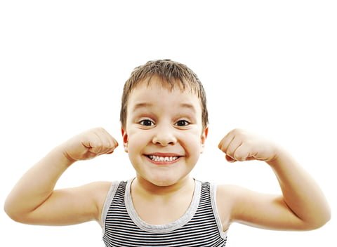 kids flexing muscles and his strong healthy teeth and enamel